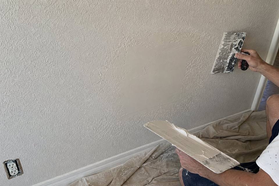 Drywall texture being matched and blended over a wall repair in Brevard County